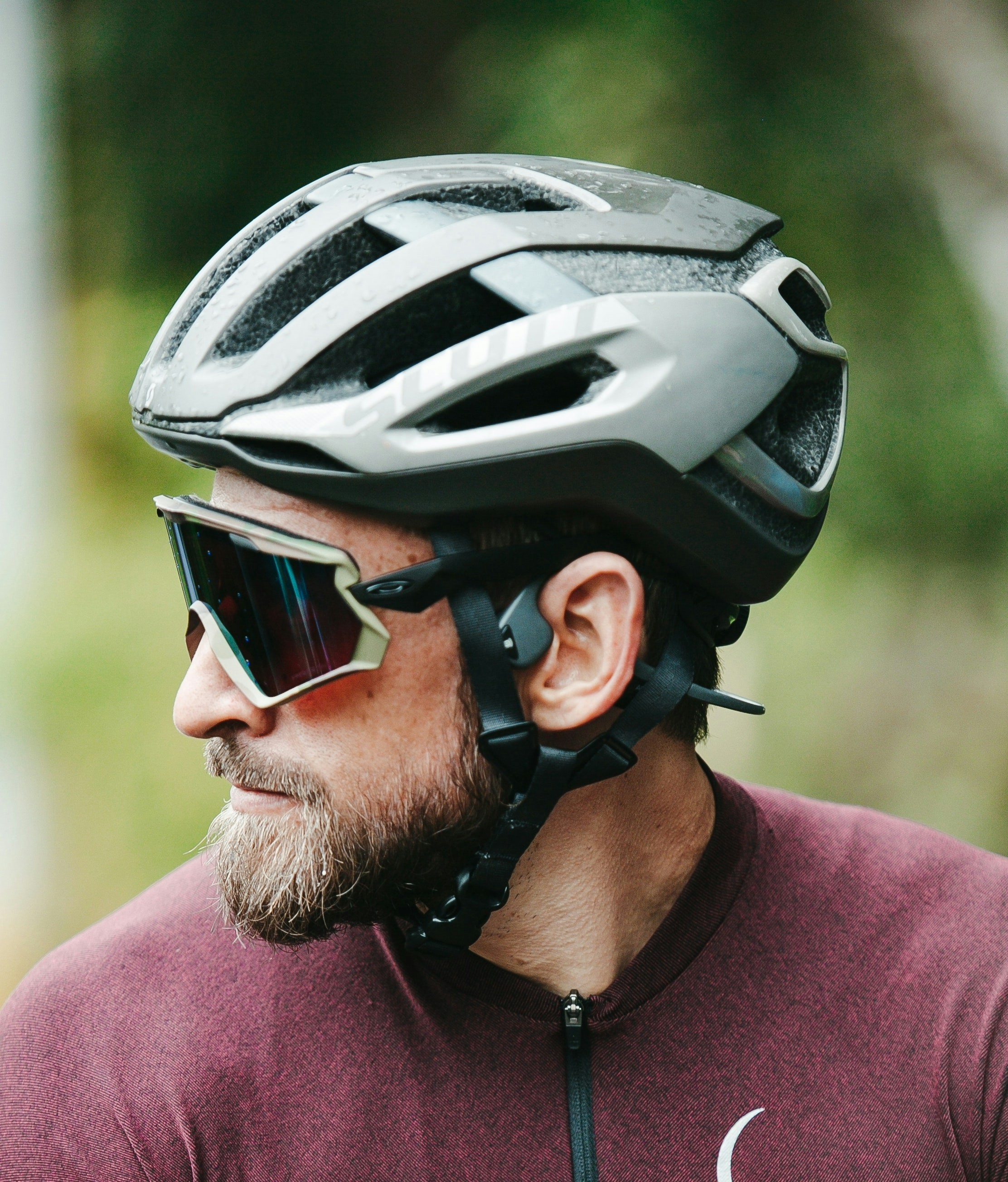 man wearing a bicycle helmet, looking right